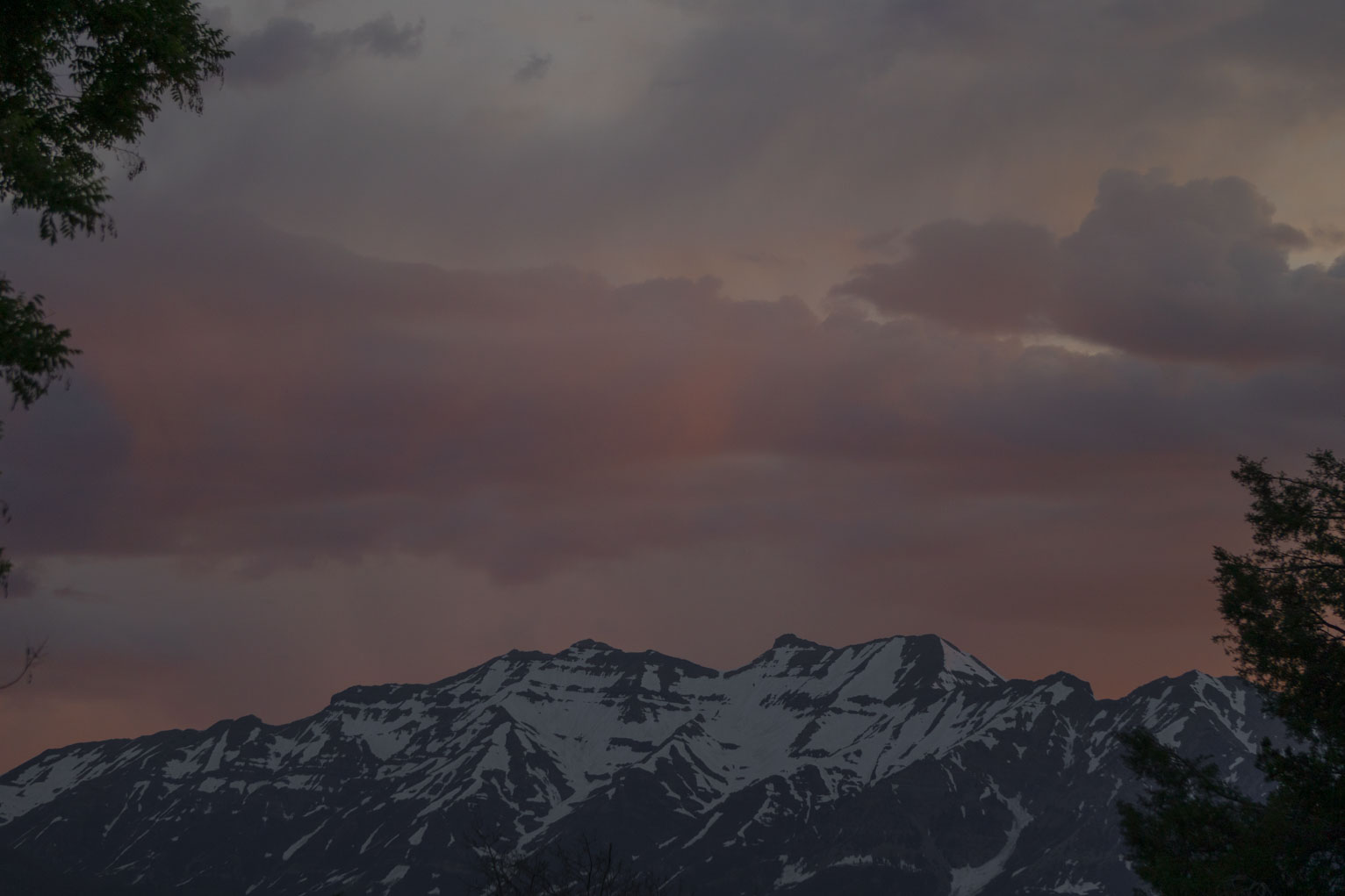 Clouds lit reddish above mountain in the morning